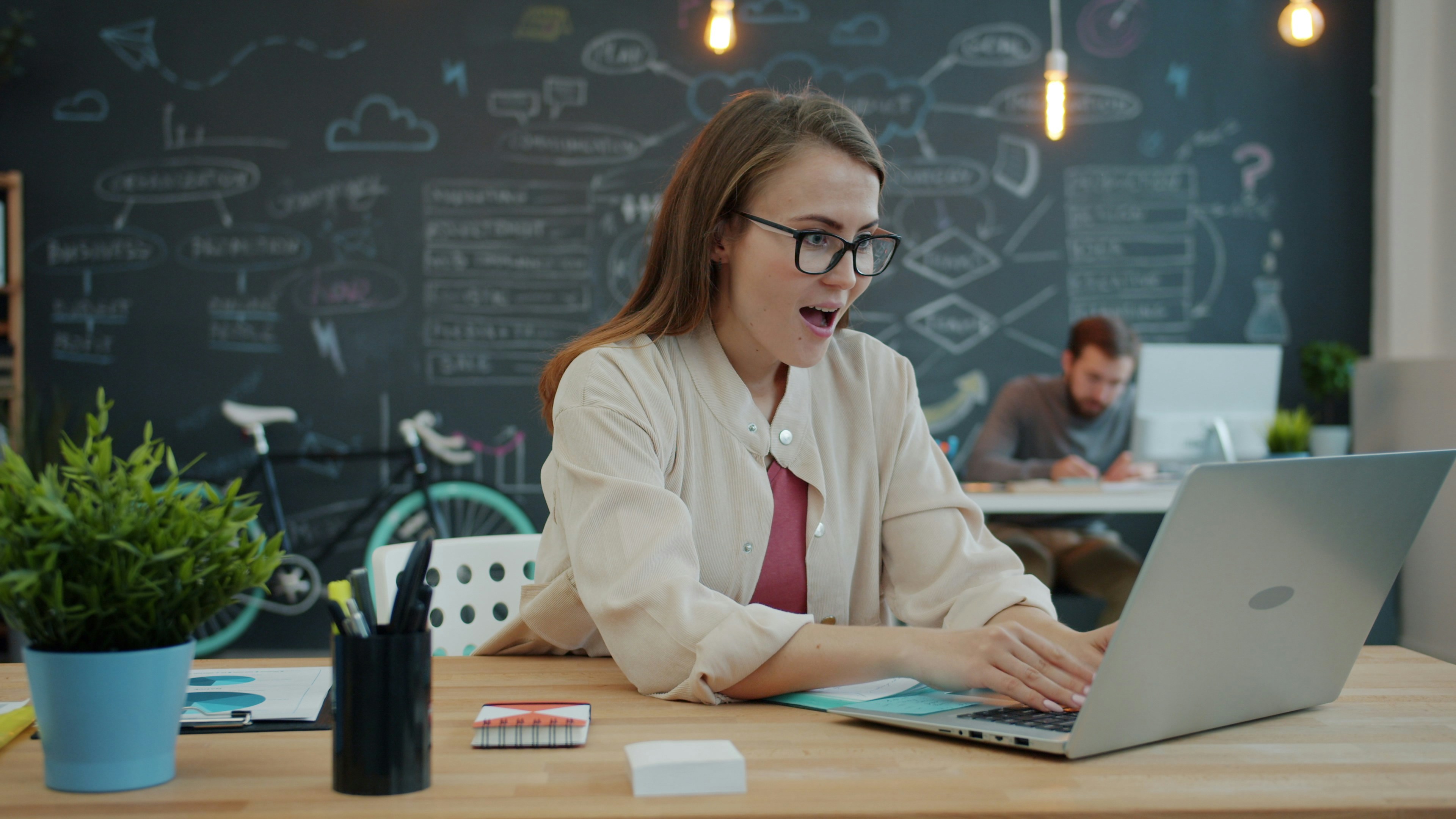 Woman excitedly working on a laptop in an office